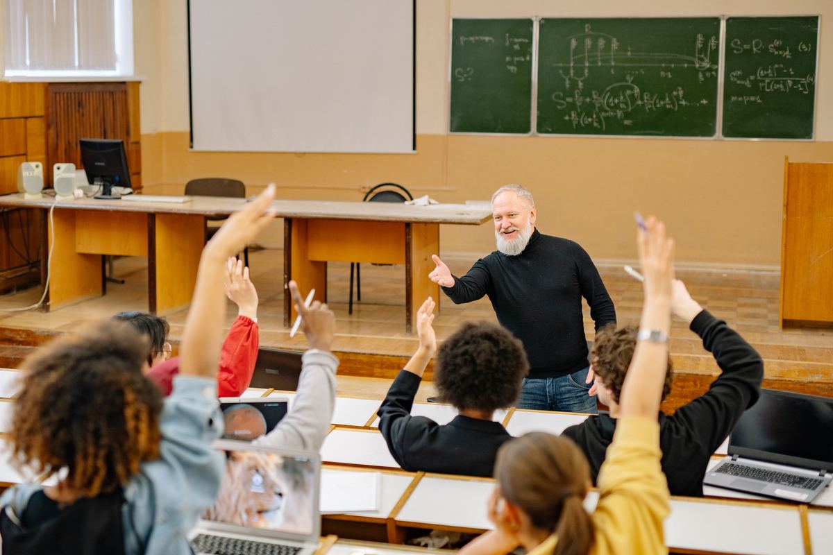 A lecturer taking questions from a hall of adult students